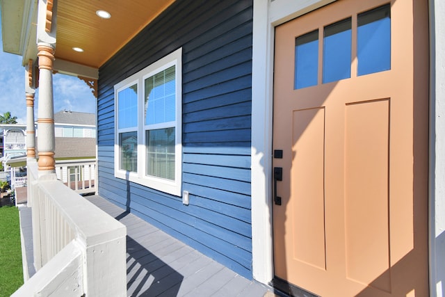 view of exterior entry featuring covered porch