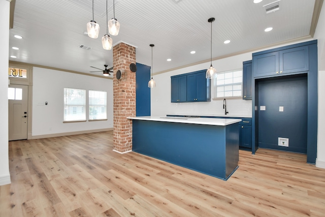 kitchen featuring blue cabinets, ornamental molding, and pendant lighting