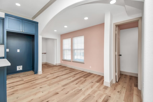 kitchen with ornamental molding, blue cabinetry, and light wood-type flooring