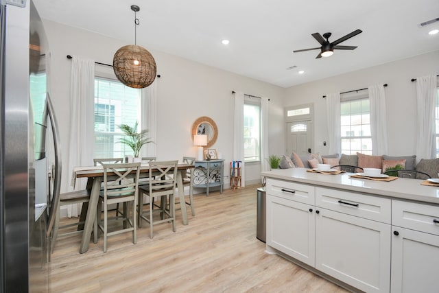 kitchen featuring stainless steel refrigerator with ice dispenser, white cabinetry, pendant lighting, ceiling fan, and light hardwood / wood-style floors