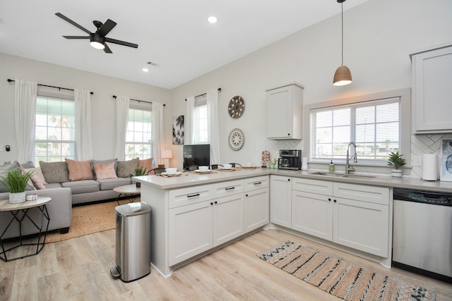 kitchen with pendant lighting, white cabinetry, dishwasher, sink, and kitchen peninsula