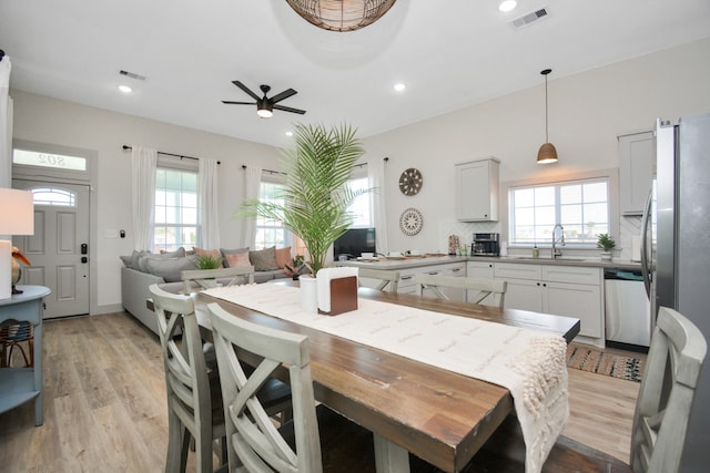 dining room with ceiling fan, plenty of natural light, sink, and light wood-type flooring