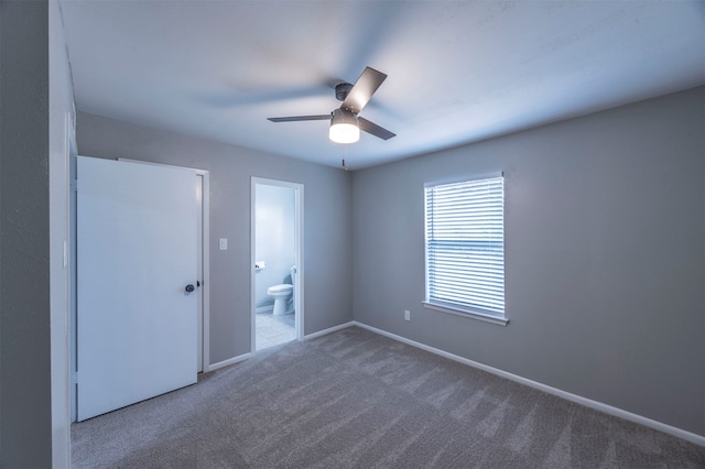 unfurnished bedroom with connected bathroom, ceiling fan, and dark carpet