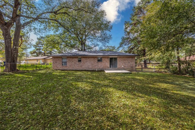 back of property featuring a patio and a yard