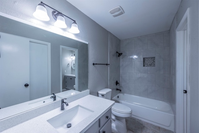 full bathroom featuring toilet, tiled shower / bath combo, vanity, and tile patterned floors