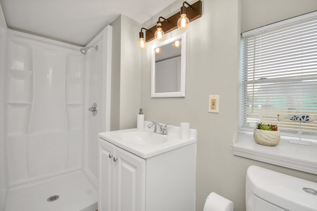 bathroom featuring walk in shower, vanity, and toilet