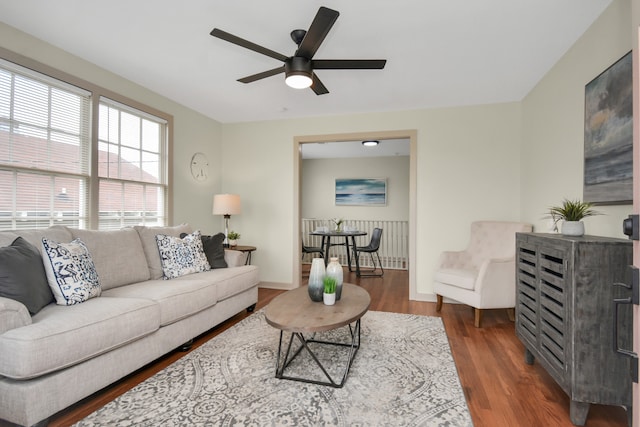 living room with dark hardwood / wood-style flooring and ceiling fan