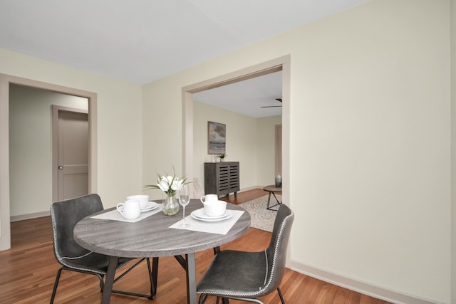 dining space with hardwood / wood-style floors and ceiling fan