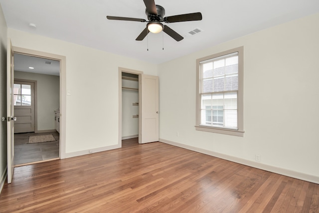 unfurnished bedroom featuring hardwood / wood-style flooring, ceiling fan, and a closet