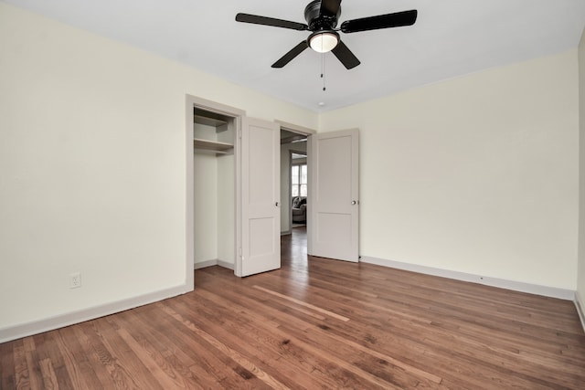 unfurnished bedroom featuring ceiling fan, wood-type flooring, and a closet