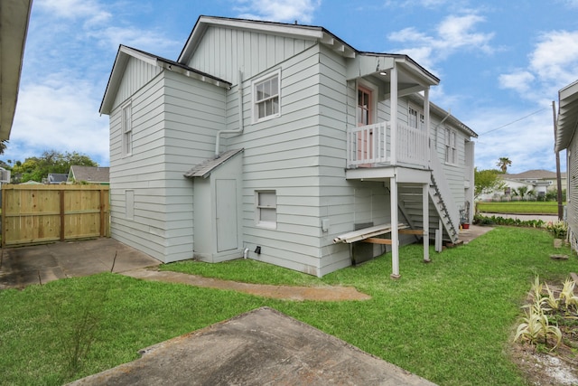 back of property featuring a lawn and a patio