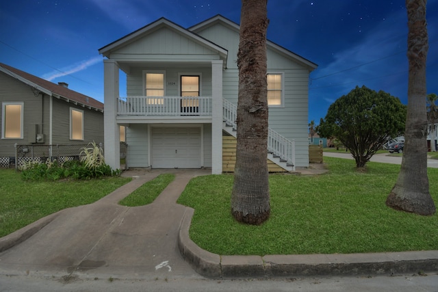 view of front of house with a front yard, covered porch, and a garage