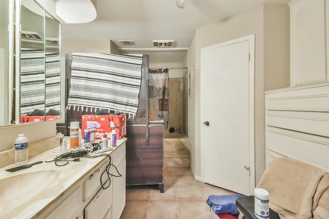 bathroom featuring tile patterned flooring, vanity, and a shower