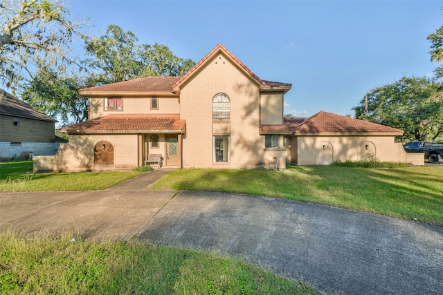 mediterranean / spanish home featuring a front lawn