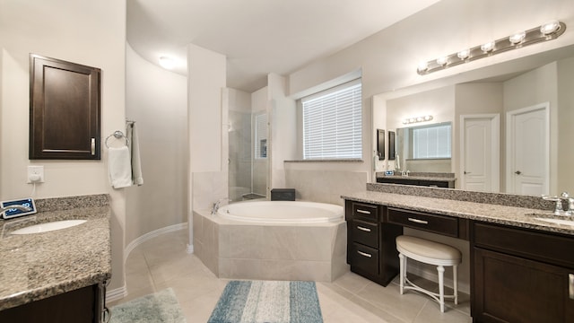 bathroom with tile patterned flooring, vanity, and a relaxing tiled tub