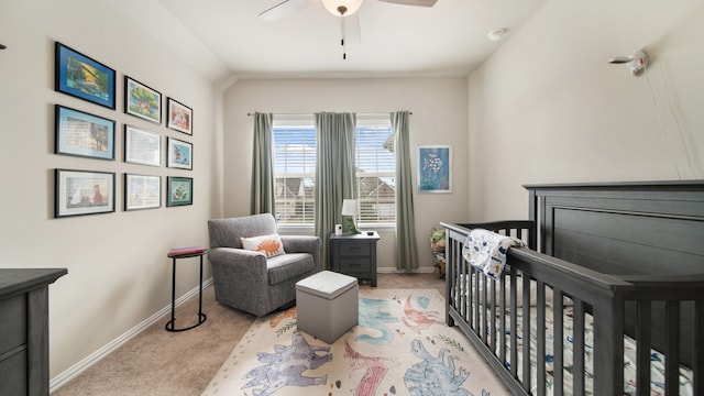 bedroom featuring ceiling fan, a crib, light carpet, and lofted ceiling