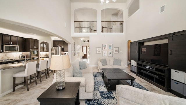 living room with sink and a high ceiling