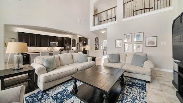 living room featuring light tile patterned floors and a towering ceiling