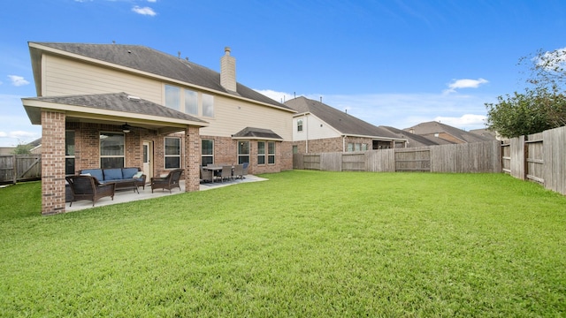 rear view of house featuring ceiling fan, a yard, a patio, and an outdoor hangout area