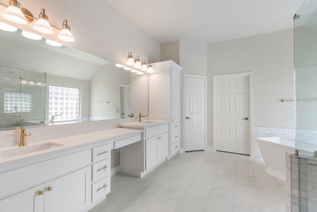 bathroom featuring vanity, independent shower and bath, and vaulted ceiling