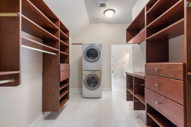 laundry room featuring stacked washer / drying machine