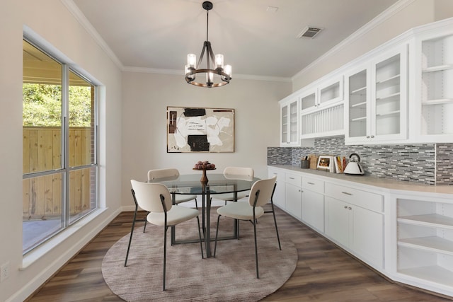 dining area with ornamental molding, dark hardwood / wood-style flooring, and a notable chandelier