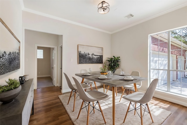 dining room featuring dark hardwood / wood-style flooring and crown molding