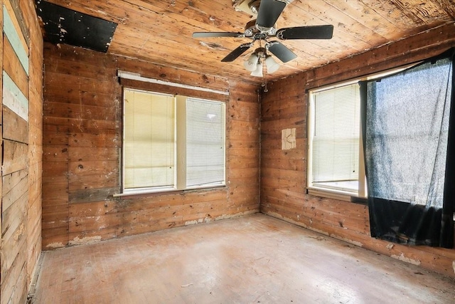 empty room with a wealth of natural light, wooden walls, ceiling fan, and wooden ceiling