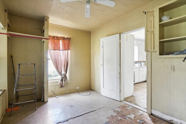 interior space with ceiling fan and ensuite bathroom