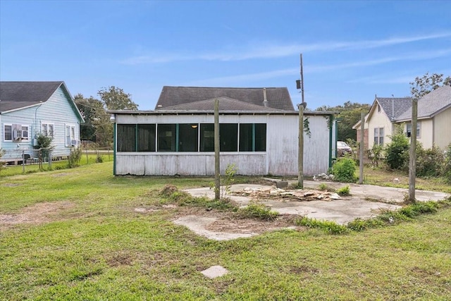 back of house with a sunroom and a yard