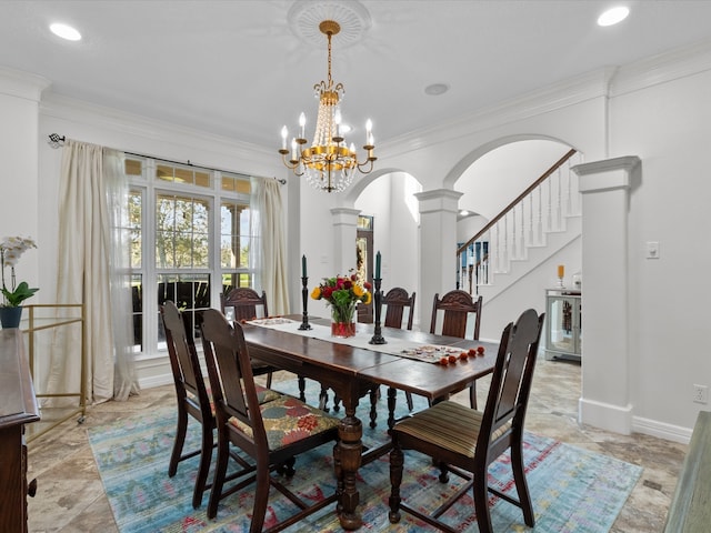 dining room featuring ornamental molding, a notable chandelier, and decorative columns