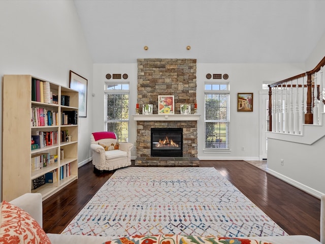 living room with a fireplace, vaulted ceiling, and dark hardwood / wood-style flooring