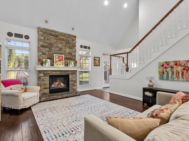 living room featuring a stone fireplace, high vaulted ceiling, and dark wood-type flooring