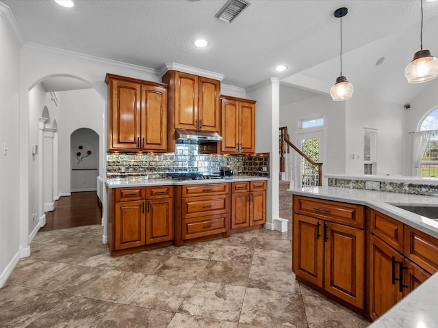 kitchen with a wealth of natural light, a textured ceiling, decorative light fixtures, and ornamental molding