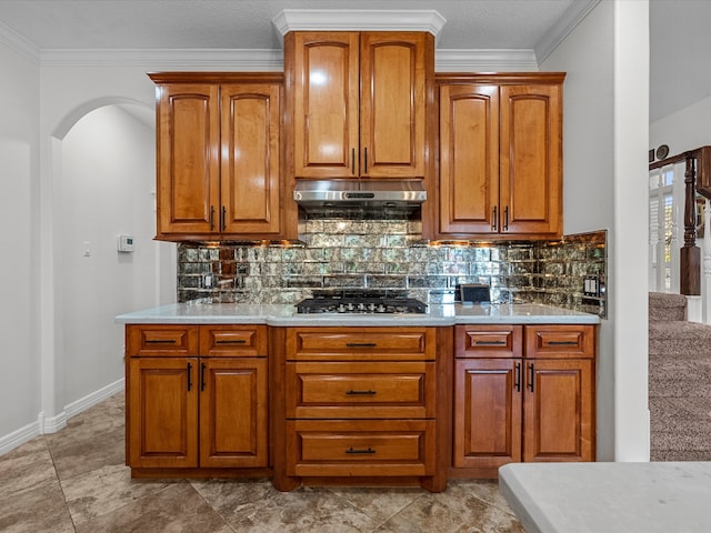 kitchen featuring stainless steel gas cooktop, tasteful backsplash, crown molding, and light tile patterned floors