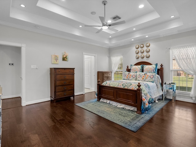 bedroom featuring dark wood-type flooring, ceiling fan, and a raised ceiling