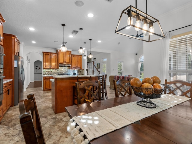 dining area featuring a wealth of natural light, vaulted ceiling, and crown molding