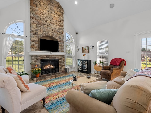 living room featuring a stone fireplace and high vaulted ceiling