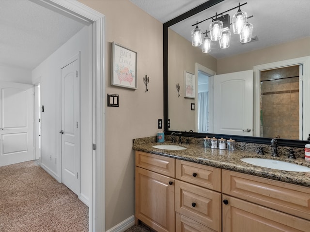 bathroom with walk in shower, vanity, and a textured ceiling