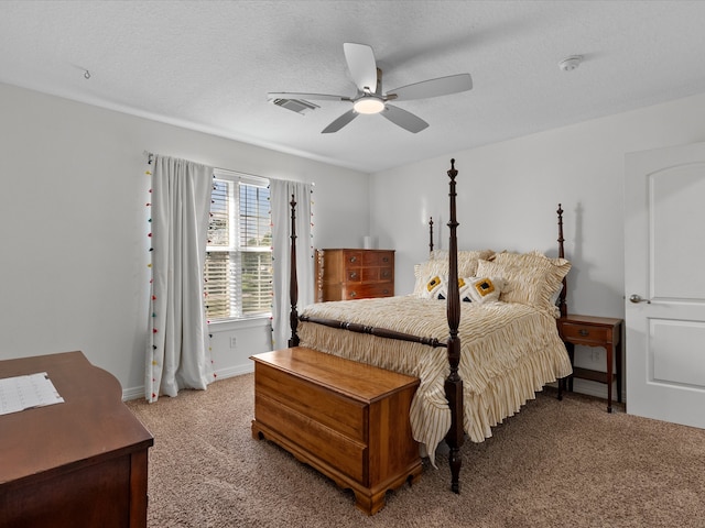 carpeted bedroom with ceiling fan and a textured ceiling