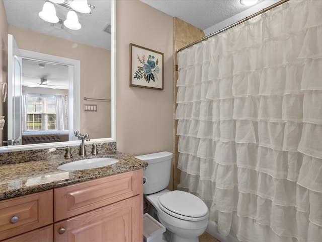 bathroom with toilet, curtained shower, a textured ceiling, vanity, and ceiling fan