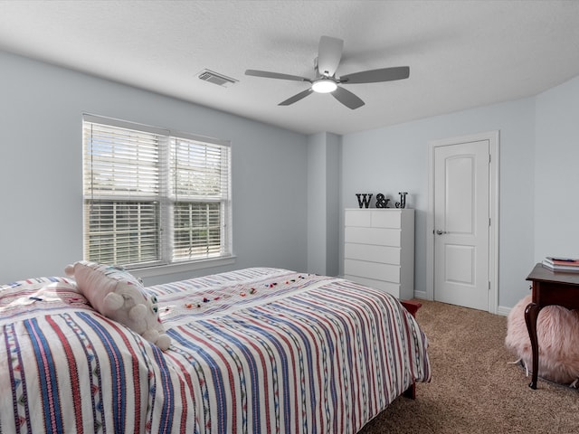 bedroom featuring a textured ceiling, carpet floors, and ceiling fan