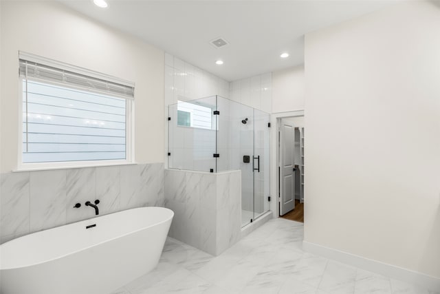 bathroom with tile walls and plus walk in shower