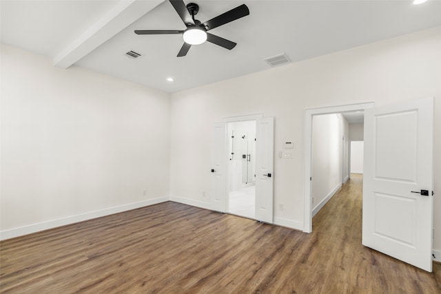 empty room featuring beamed ceiling, wood-type flooring, and ceiling fan