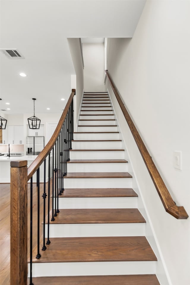 stairway featuring a chandelier and hardwood / wood-style floors