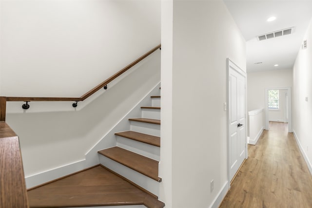 staircase with hardwood / wood-style floors