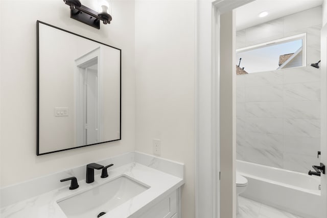 full bathroom with vanity, tiled shower / bath combo, and toilet