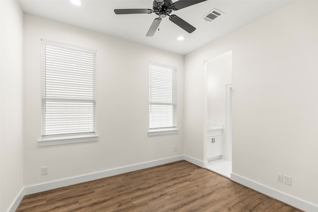 spare room with wood-type flooring, plenty of natural light, and ceiling fan