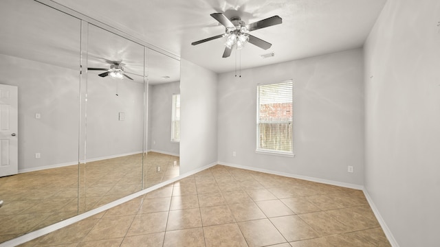 tiled empty room with basketball court and ceiling fan