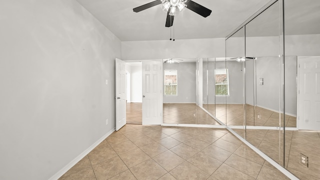 unfurnished bedroom featuring a closet, light tile patterned floors, and ceiling fan